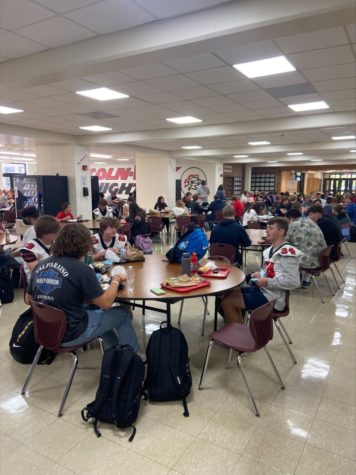 Students eat lunch 6 to a table.